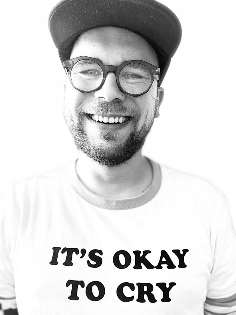 Michał Maciejak, czarno-biały portret w koszulce z napisem „It’s okay to cry”